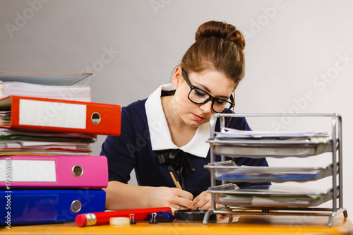 Business woman in office writing something down