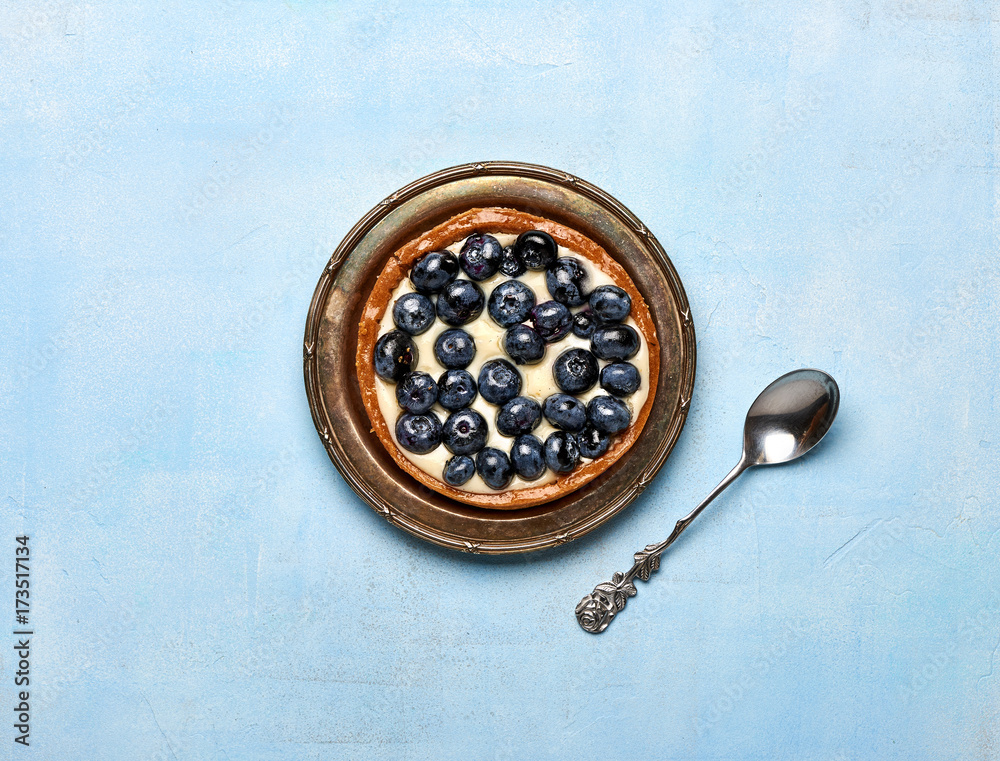 Blueberry tart, pie, tartlet with custard on blue stone background. Blueberry tart, pie, tartlet with custard on blue stone background.