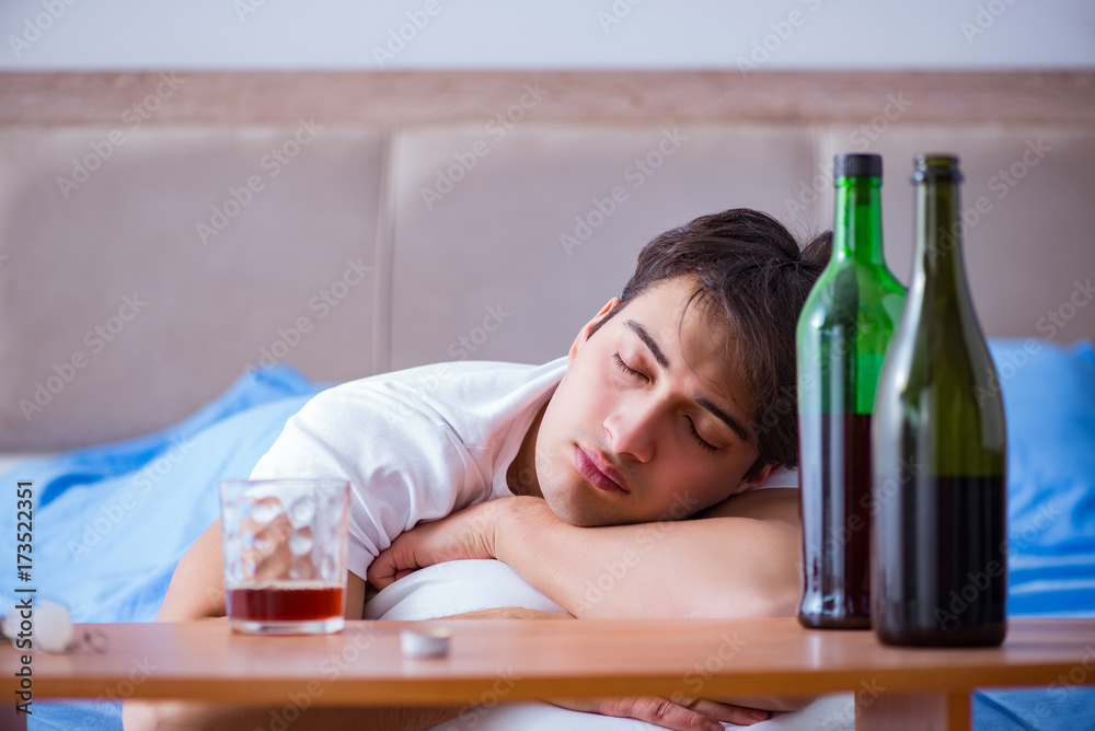 Man alcoholic drinking in bed going through break up depression Man alcoholic drinking in bed going through break up depression