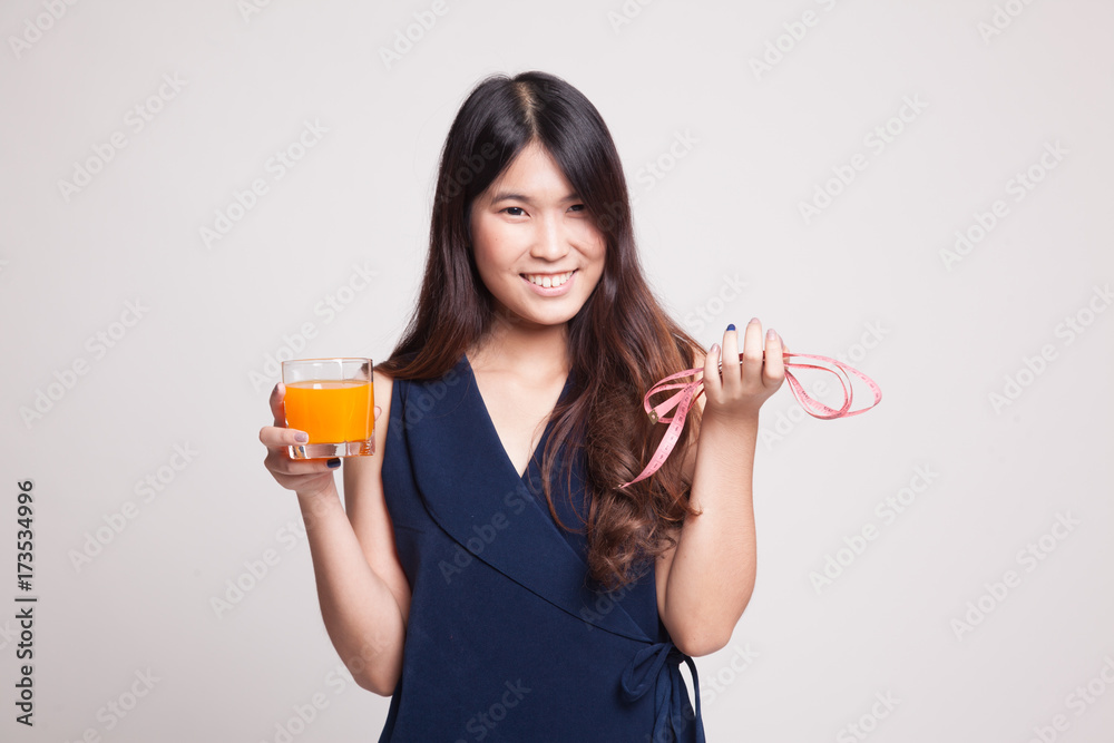 Asian woman drink orange juice hold measuring tape. Asian woman drink orange juice hold measuring tape.