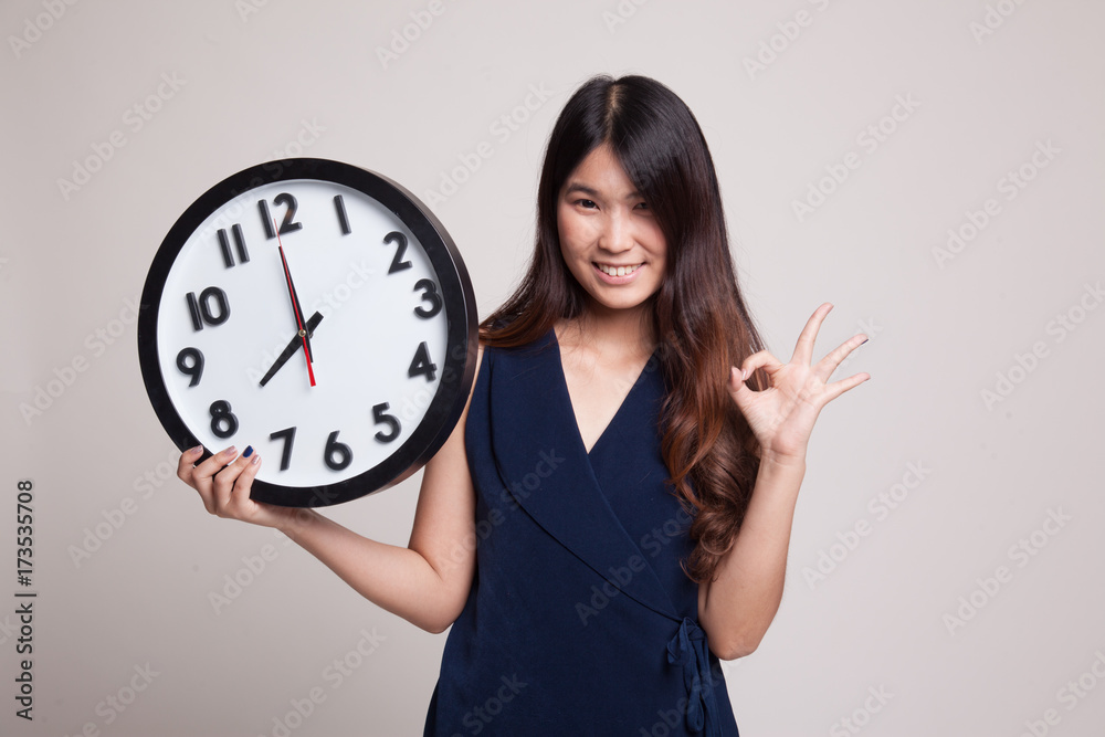 Young Asian woman show OK with a clock. Young Asian woman show OK with a clock.