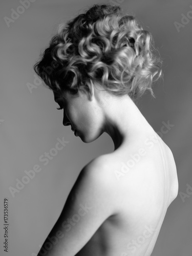 Nude woman with elegant hairstyle on gray background