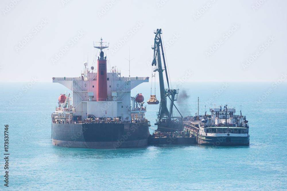 Dry cargo vessel transferring a cargo at sea.