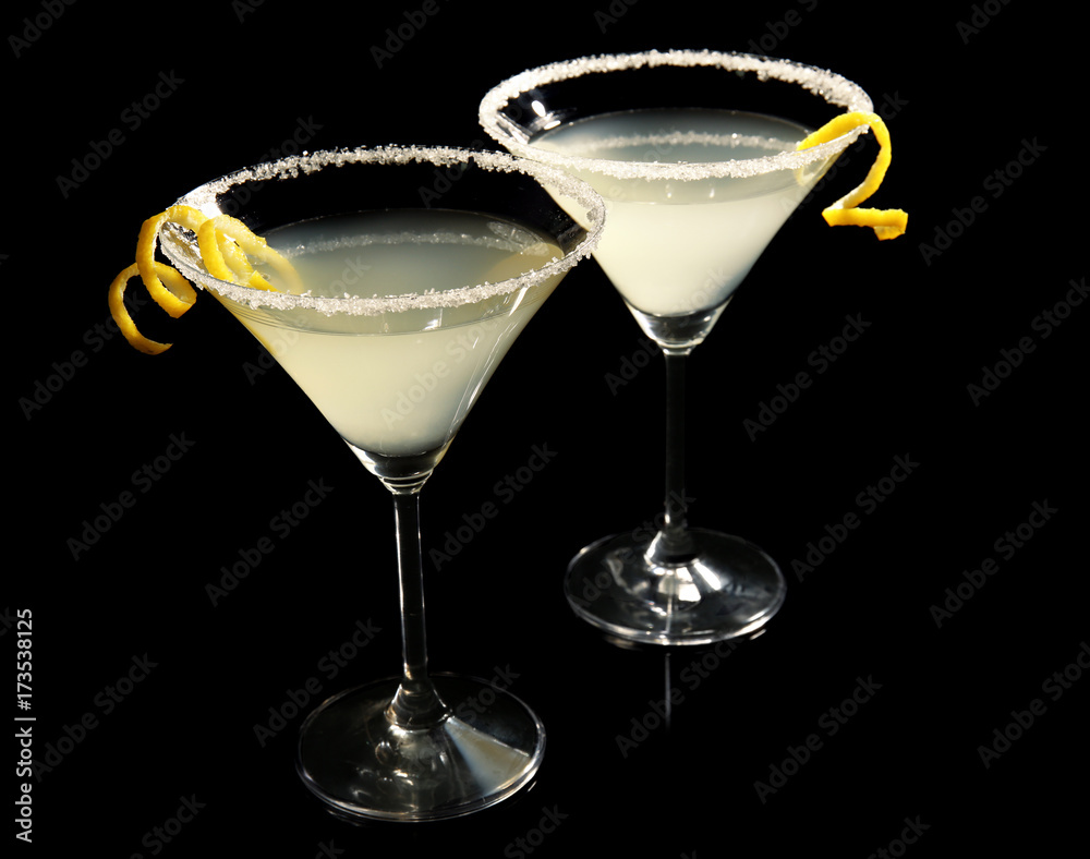 Glasses of lemon drop martini with zest on black background