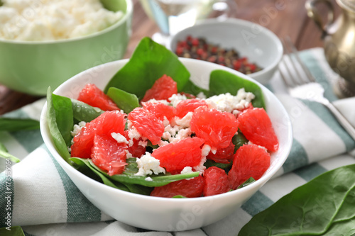Plate of salad with spinach, grapefruit and cottage cheese on table