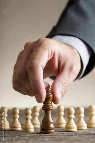 Human hand moving queen chess figure