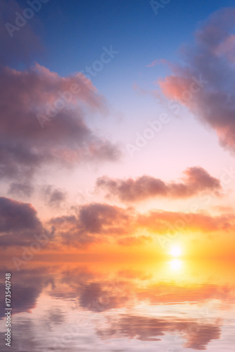 Soft sunset in the sky and clouds over the calm sea. © Sviatoslav Khomiakov