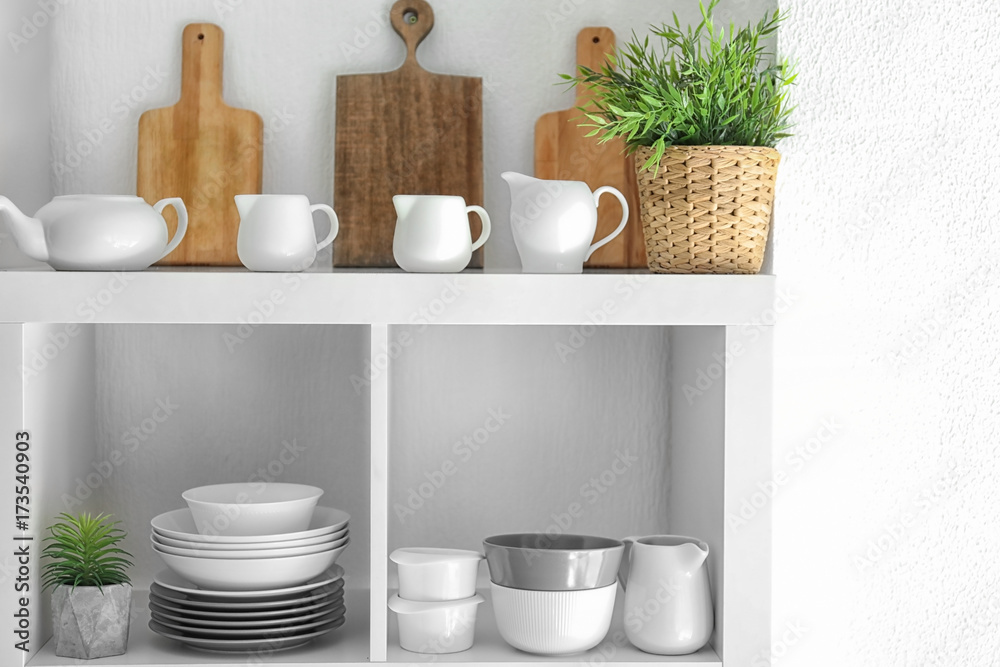 Kitchen shelving with dishes on white wall background Kitchen shelving with dishes on white wall background