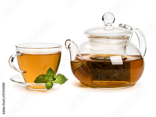 Fresh mint and green tea in a cup and a teapot from glass