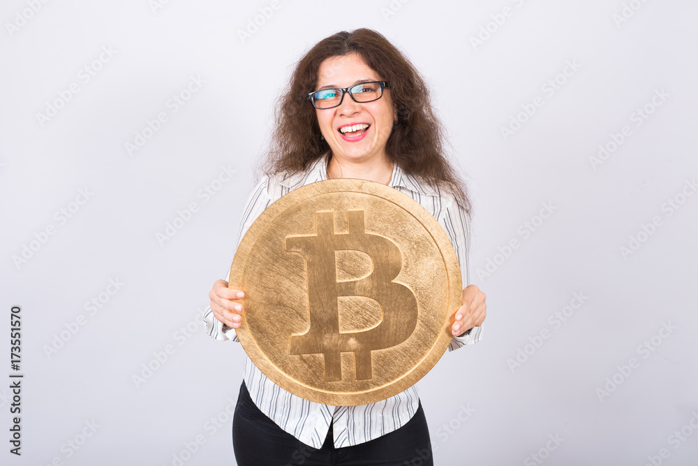 Business woman holding a Golden Bitcoin. Virtual money. Business woman holding a Golden Bitcoin. Virtual money.