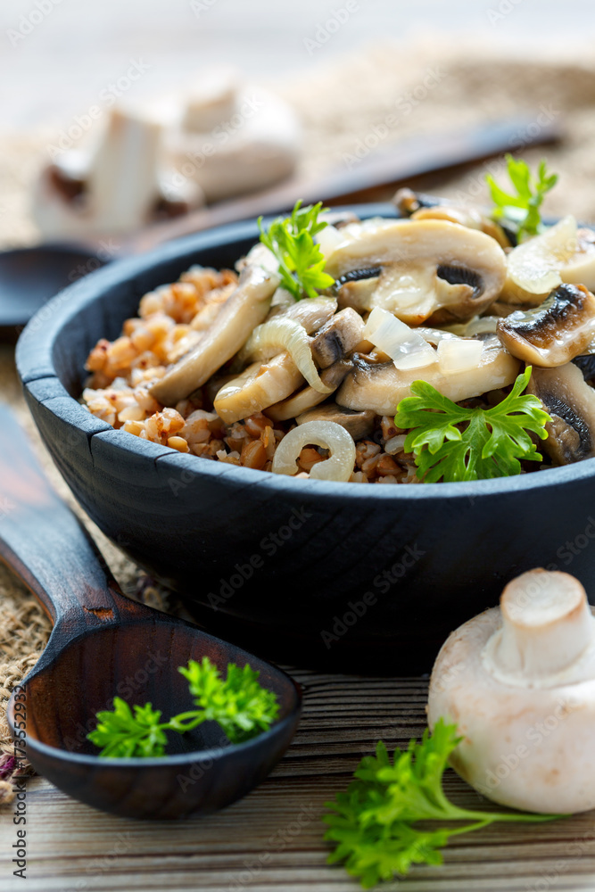 Buckwheat porridge with mushrooms in a wooden bowl. Buckwheat porridge with mushrooms in a wooden bowl.