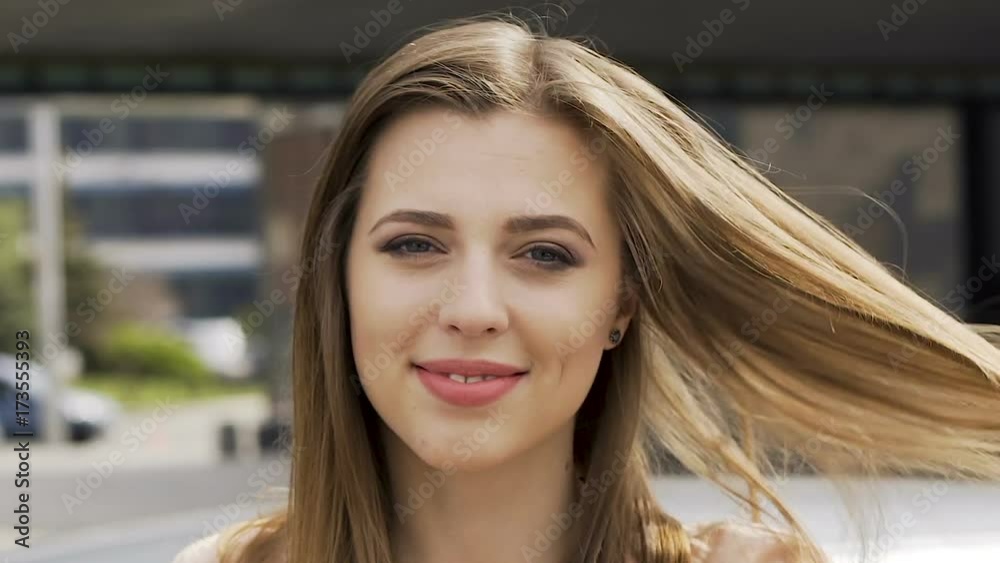 Young successful lady adjusting hair smiling and looking at camera, face closeup Young successful lady adjusting hair smiling and looking at camera, face closeup