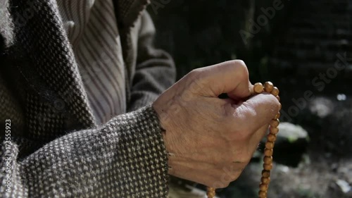 Old man holding prayer beads in hand