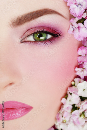 Close-up portrait of girl with stylish makeup and flowers around her face