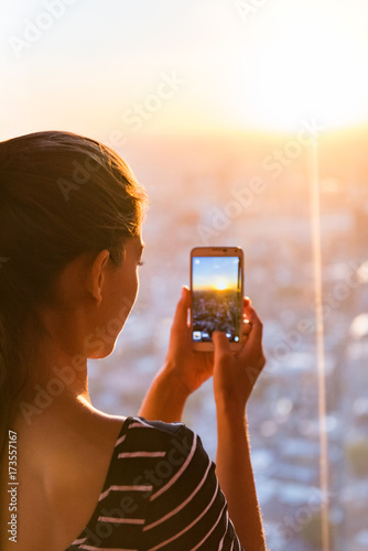 Canvas Print Tourist girl taking phone picture of sunset london skyline view from The Shard