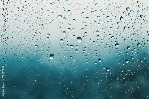 Raindrops on the glass, blurry landscape on background