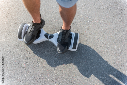 Male feet going on hoverboard at street
