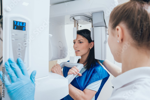 Quadro em tela Young woman patient standing in x-ray machine.