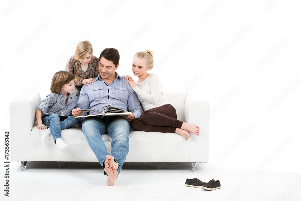 Happy family on the couch read the book together isolated. Happy family on the couch read the book together isolated.