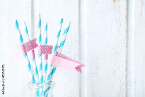 Striped drink straws on white wooden wall paneling background
