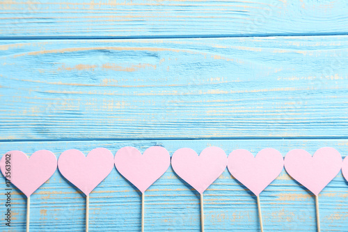 Pink paper hearts on blue wooden table