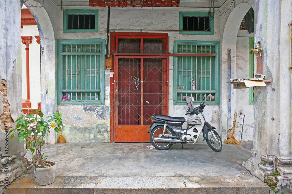Quintessential Malaysia doorway scene with motorbike, typical across SE Asia, as seen in Penang