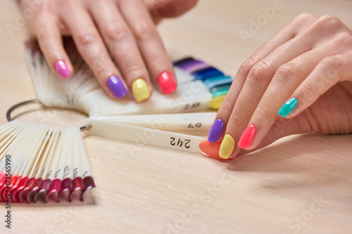 Female hand holding nails colors samples. Womans summer shellac nails. Choice summer fashion manicure.