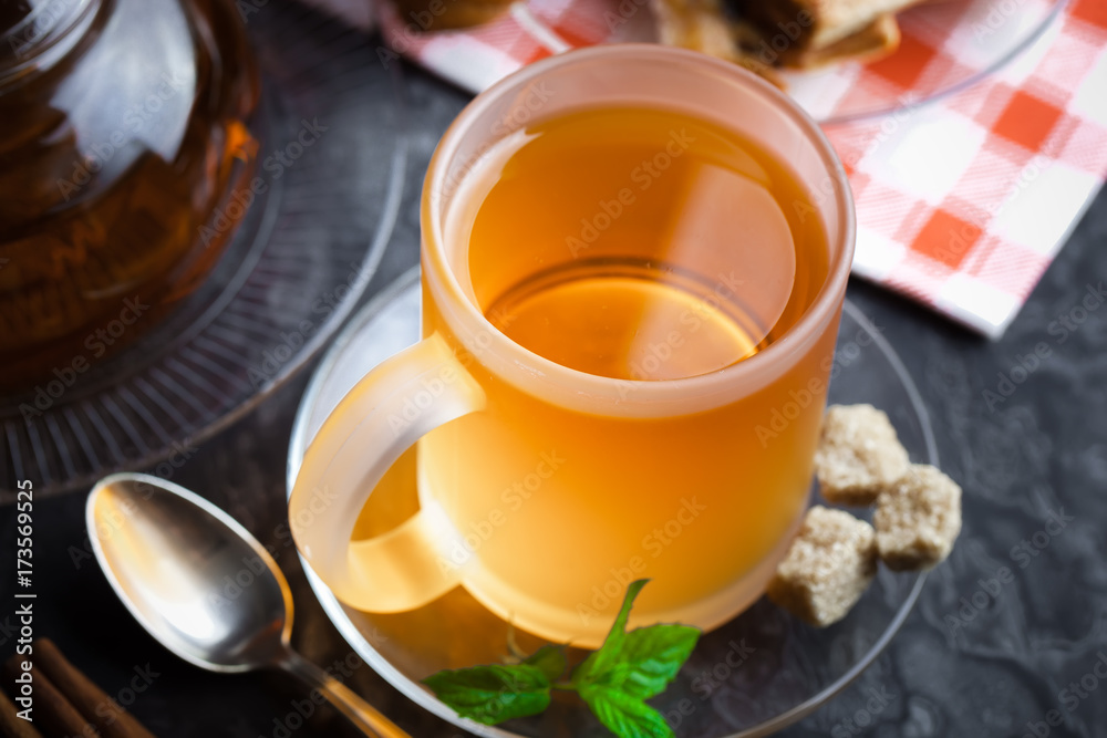 Tea in a cup on a metallic background in a composition with a cookware Tea in a cup on a metallic background in a composition with a cookware