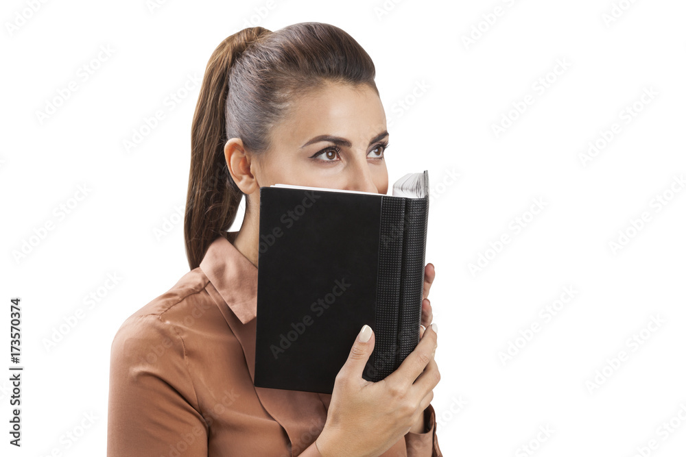 Businesswoman in brown covering face with planner Businesswoman in brown covering face with planner