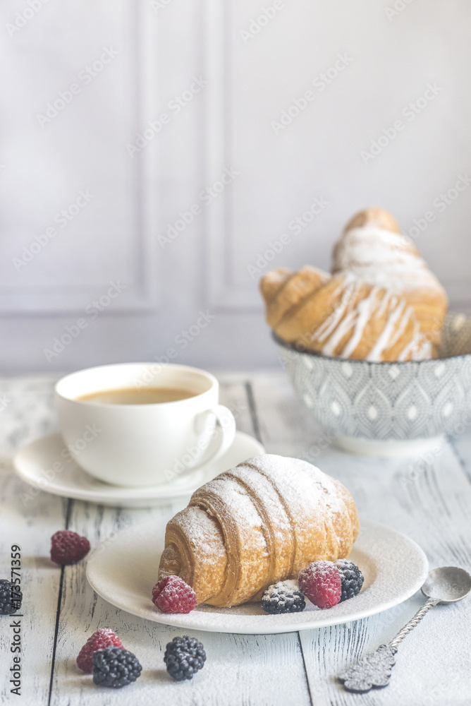 Croissants with fresh berries and a cup of coffee Croissants with fresh berries and a cup of coffee