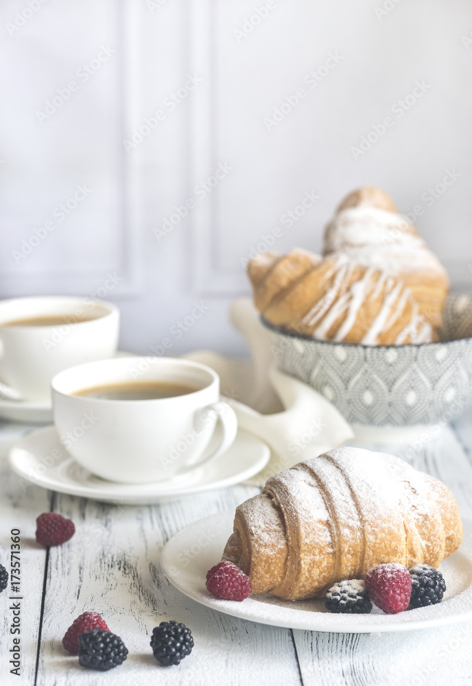 Croissants with fresh berries and two cups of coffee Croissants with fresh berries and two cups of coffee