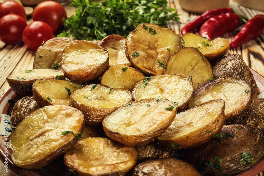 Obraz premium Close up of steaming hot baked potato,Hot buttered jacket baked potatoes,Roasted potato in bowl on wooden table,Oven-baked potatoes with sea salt and rosemary,toasted baked potato strewed with herbs.