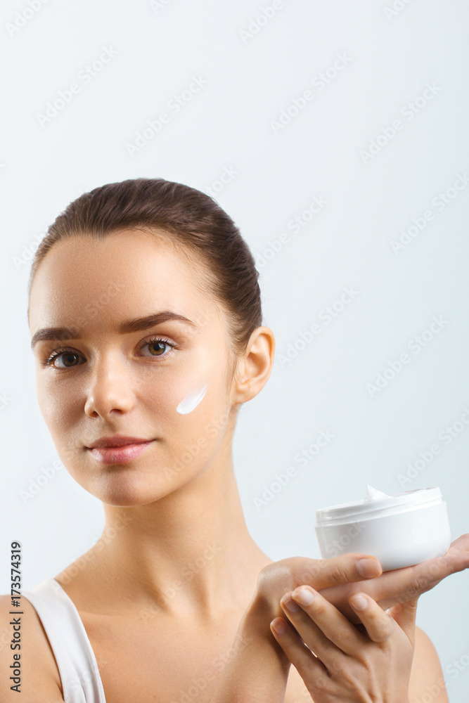Skincare. Beauty Concept. Young pretty woman holding cosmetic cream Skincare. Beauty Concept. Young pretty woman holding cosmetic cream