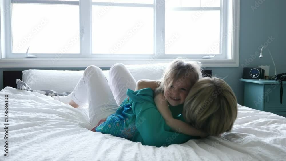 Happy loving family. Mother and her daughter child girl playing and hugging.on bed Happy loving family. Mother and her daughter child girl playing and hugging.on bed