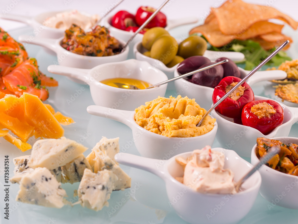 Snack set. Oktoberfest food frame concept. Variety of humus, olives, vegetables, cheese and sauces on white background. Top view Snack set. Oktoberfest food frame concept. Variety of humus, olives, vegetables, cheese and sauces on white background. Top view
