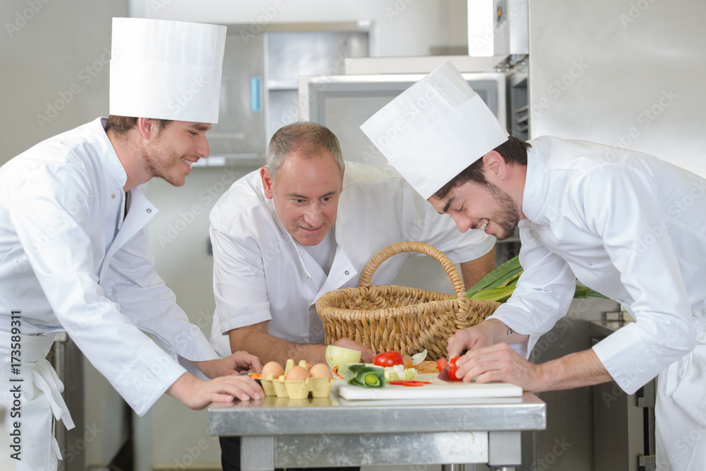 chef training students in restaurant kitchen
