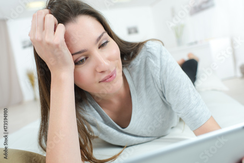 beautiful woman laying in bed using a laptop