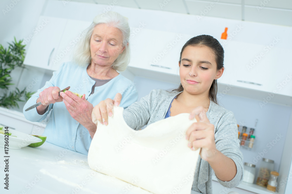 Fototapeta premium senior nanny cooking with girl