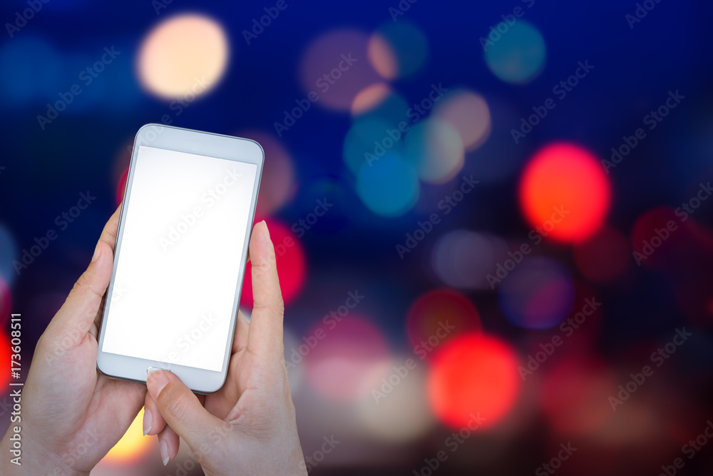 Hand holding smart phone with abstract lights bokeh on black background