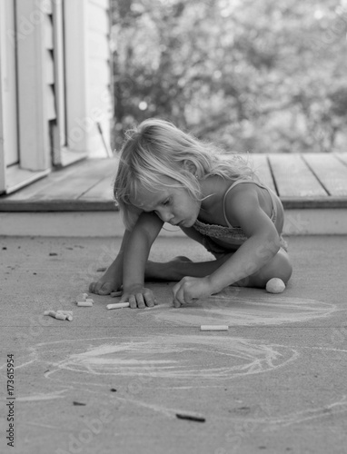 little girl Sidewalk Chalking in the summer time 