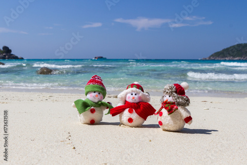 Happy snowman in Christmas Santa Claus hat on Sunny sea beach, New year holiday concept of leisure travel in the hot southern countries