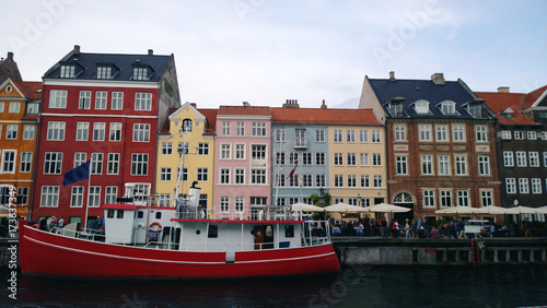 Bright beautiful facades of the buildings on the waterfront Nyhavn and the red-white ship on the water
