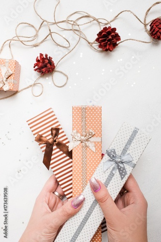 Festive background of New Year holiday. Gift boxes holding in hands and handmade decoration nearby, top view. Celebrations, Christmas, festival and paperpresents concept photo