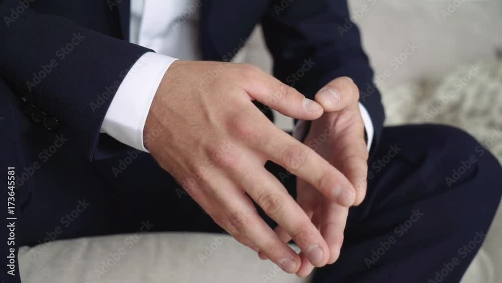 A man in a business suit is sitting with his fingers in front of him. A man in a business suit is sitting with his fingers in front of him.