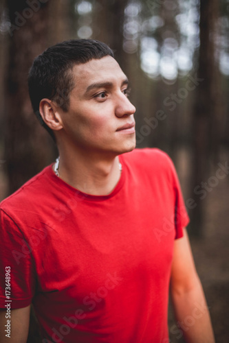 A young guy in a red T-shirt in a pine forest © bearok