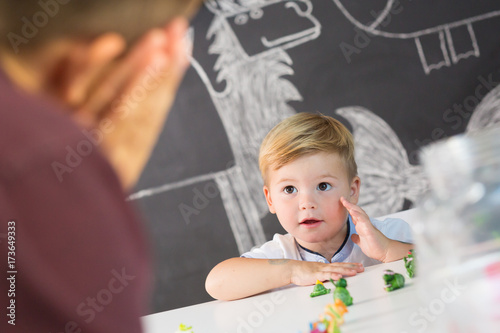 Cute little playfull toddler boy at child therapy session. Private one on one homeschooling with didactic aids. photo