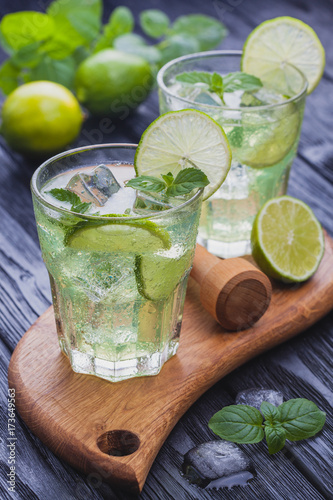 refreshing cold mojito with ice on a black wooden table