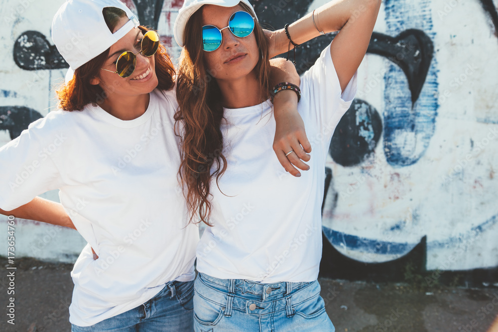Models wearing plain tshirt and sunglasses posing over street wall - obrazy, fototapety, plakaty 