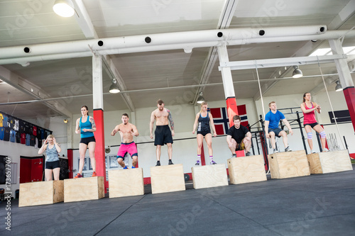 Athletes Practicing Box Jumps In Gym