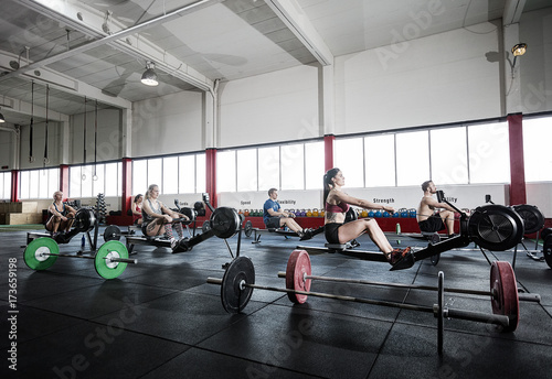 Female And Male Athletes Using Rowing Machine